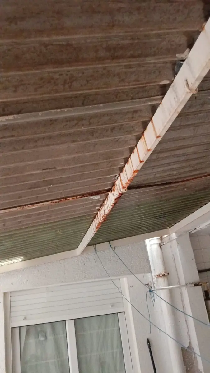 Canalón oxidado bajo el alero de un tejado