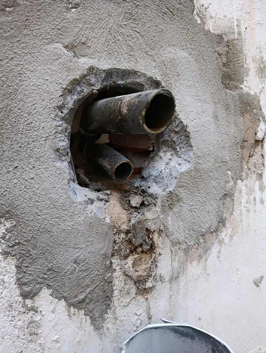 Tubería rota: Salida antigua deteriorada que filtraba agua a la fachada.